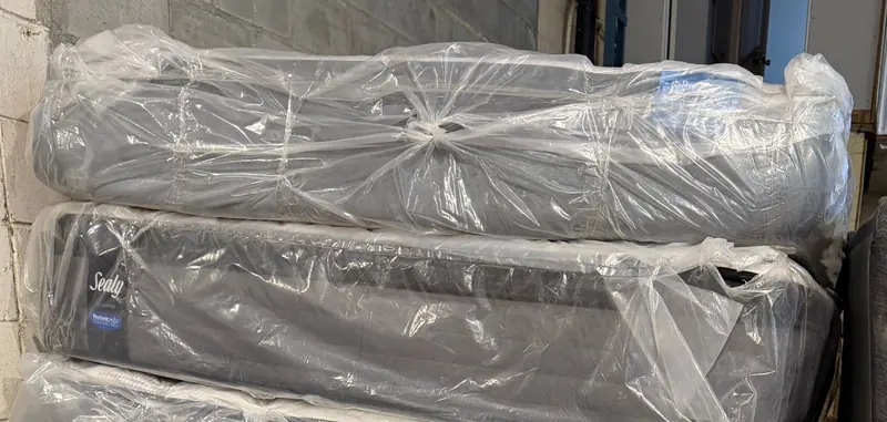 Matelas Sealy empilés dans leurs housses en plastique
